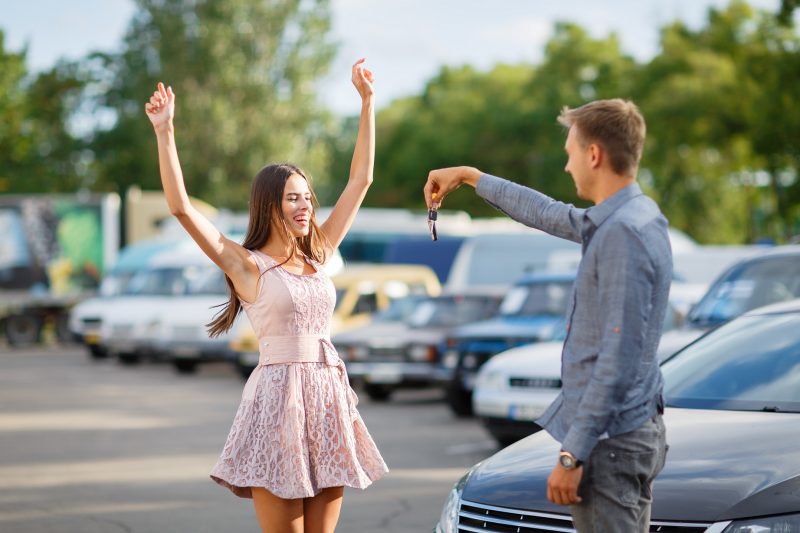 girl in pink dress exclaiming in happiness after buying a car with car finance
